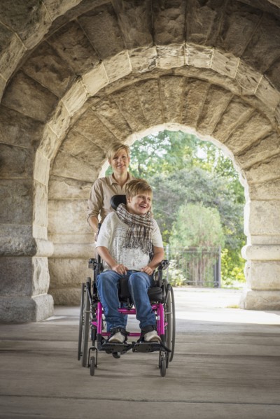 Mother pushing paraplegic daughter in wheelchair