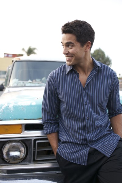 Mixed race man leaning against truck