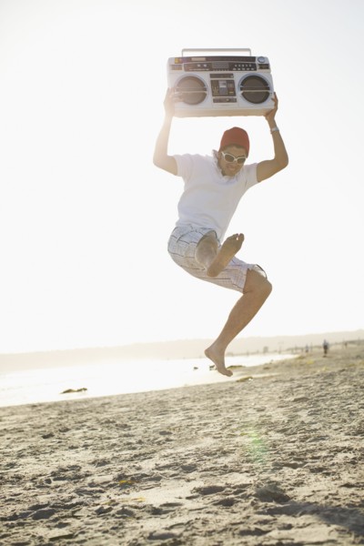 Hispanic man holding boom box and jumping