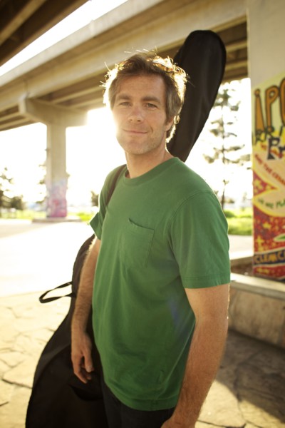 Smiling Caucasian man carrying double bass