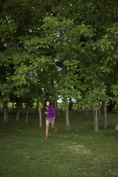 Hispanic woman running through park