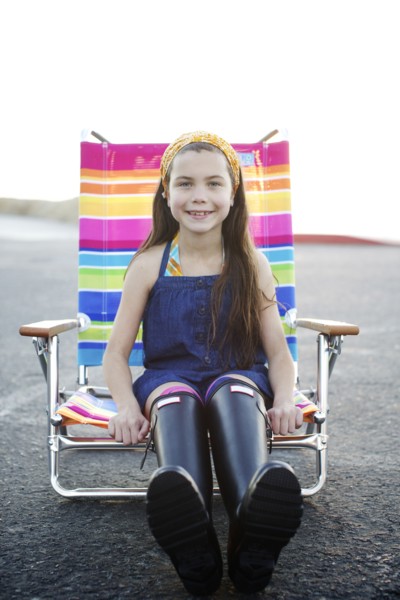 Mixed race girl sitting in lounge chair