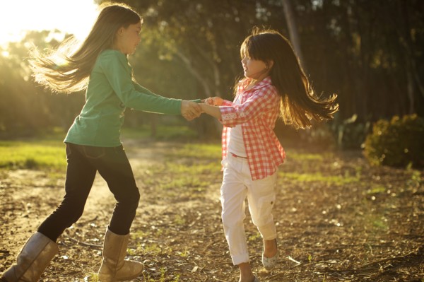 Mixed race sisters dancing in circle together