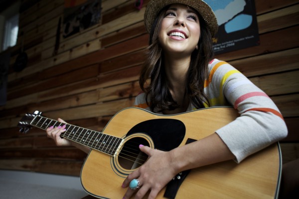 Mixed race woman playing guitar