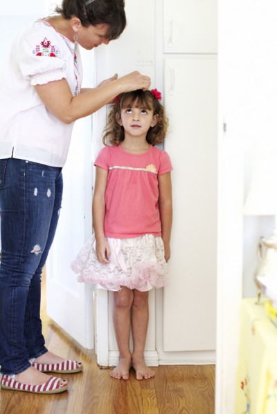 Mother measuring daughter's height