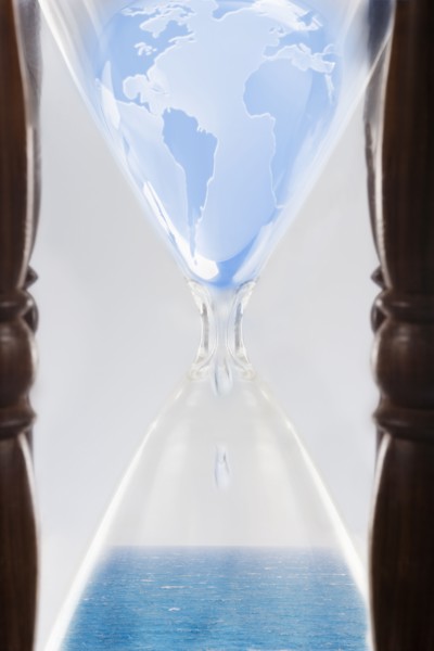 Globe squeezing through hour glass