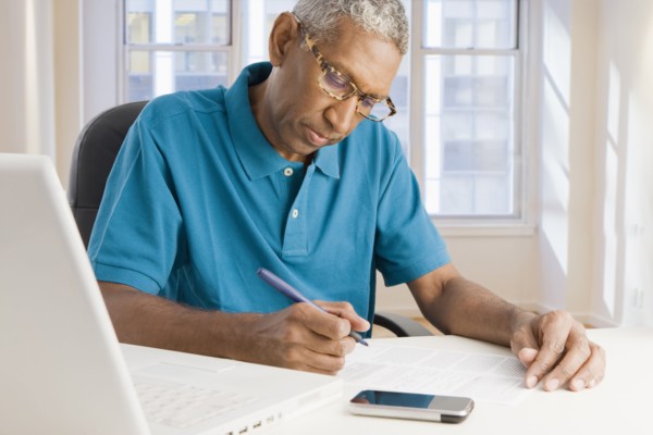 Mixed race man paying bills online
