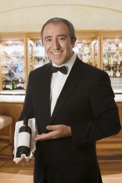 Hispanic sommelier displaying a bottle of wine