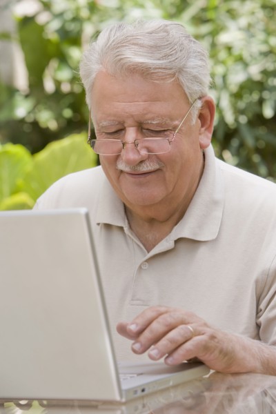 Senior Chilean man typing on laptop