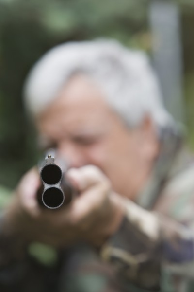 Senior Chilean man pointing shotgun