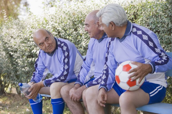 Senior Chilean soccer players sitting on bench
