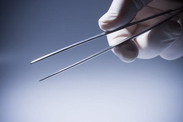 Close up of Hispanic doctor holding tweezers