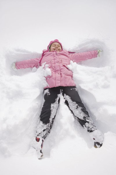 Hispanic girl making snow angel