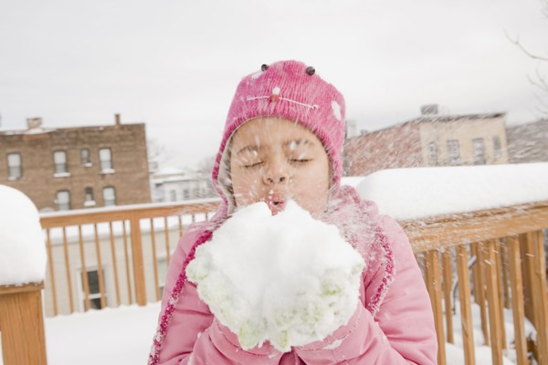 Hispanic girl playing with snowball