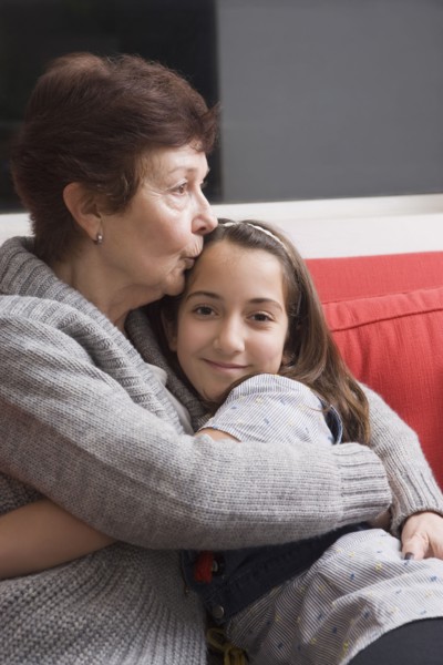 Older Hispanic woman hugging granddaughter