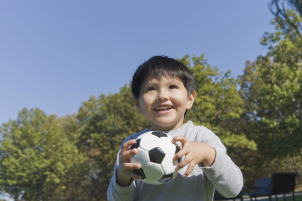 Hispanic boy playing soccer outdoors