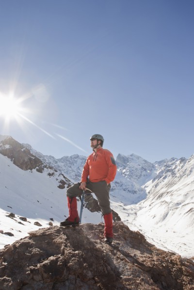 Hispanic hiker posing on snowy mountaintop