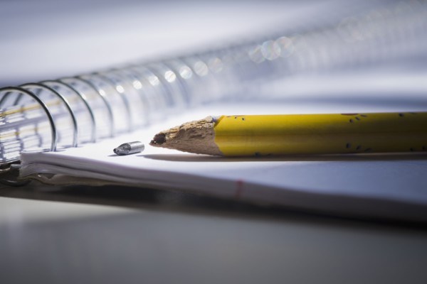Close up of broken pencil on notebook