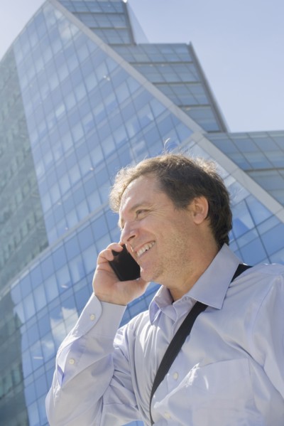 Hispanic businessman talking on cell phone on city street