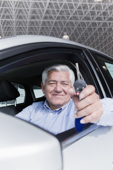 Hispanic man holding keys to new car