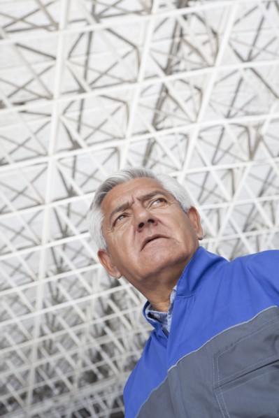 Low angle view of older Hispanic mechanic in warehouse