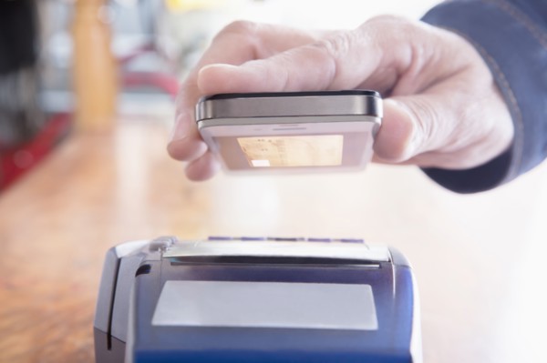 Hispanic woman scanning credit card from cell phone