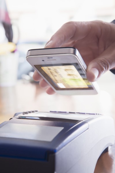 Hispanic woman scanning credit card from cell phone