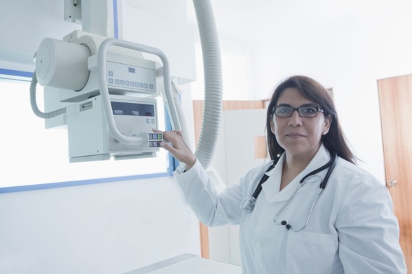 Hispanic doctor using x-ray in hospital