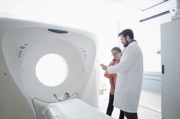 Hispanic doctor and nurse talking near scanner