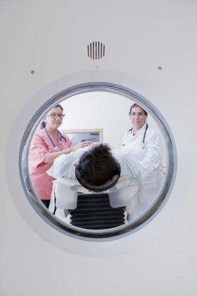 Hispanic doctor and nurse comforting patient at scanner