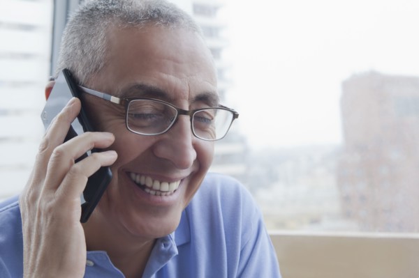 Smiling Hispanic man talking on cell phone