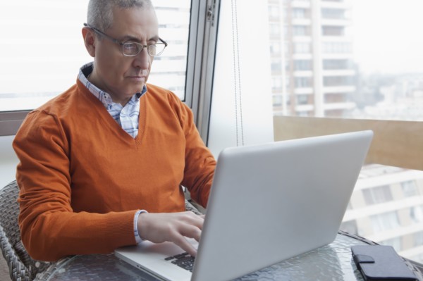 Hispanic man using laptop