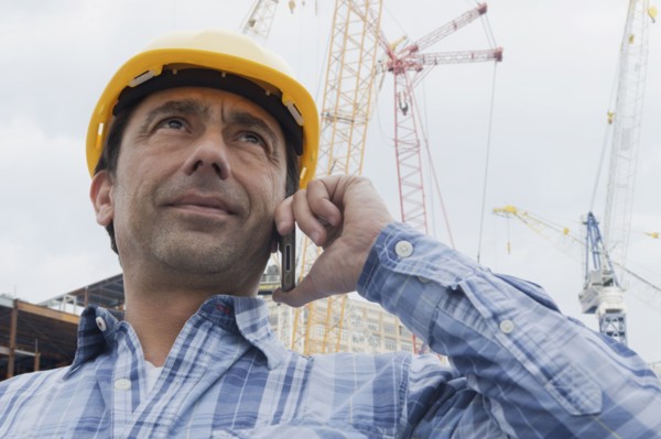Hispanic construction worker talking on cell phone