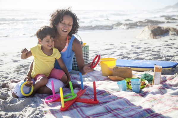 Mixed race mother and daughter playing at beach