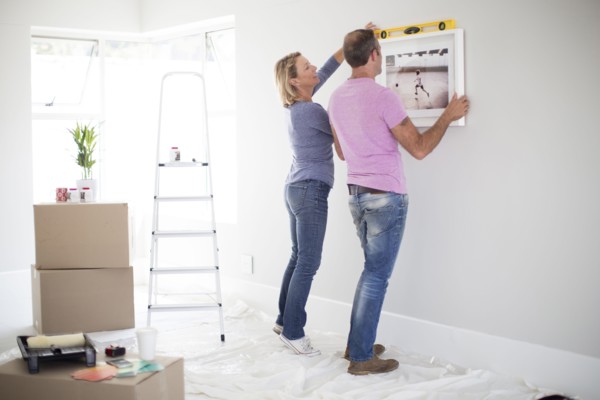 Caucasian couple using level in new home
