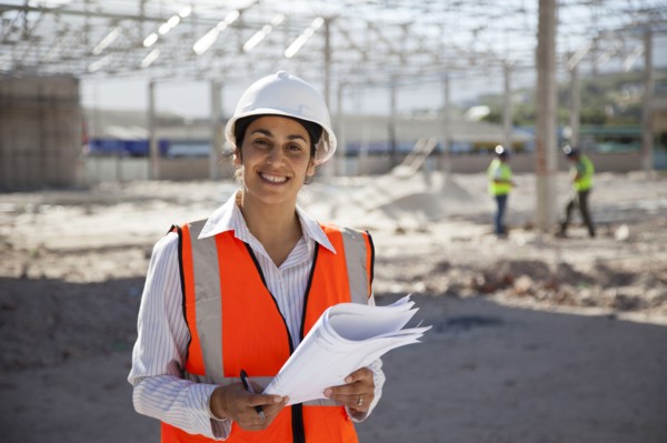 Architect holding blueprints at construction site