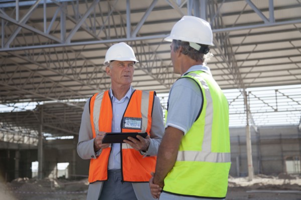 Caucasian architects talking at construction site