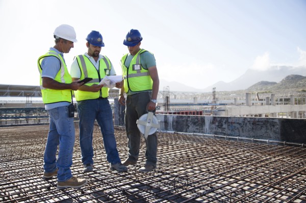 Construction workers talking on rebar at construction site