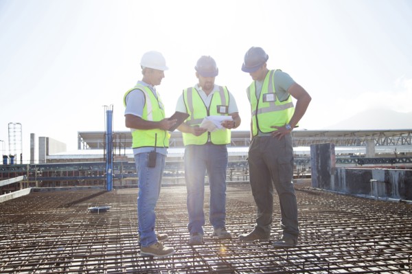 Construction workers talking on rebar at construction site