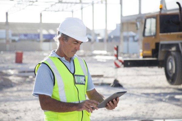 Caucasian construction worker using digital tablet at construction site
