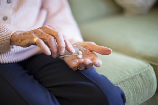 Older Caucasian woman holding medication
