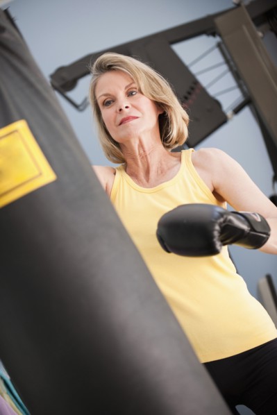 Caucasian woman boxing with punching bag