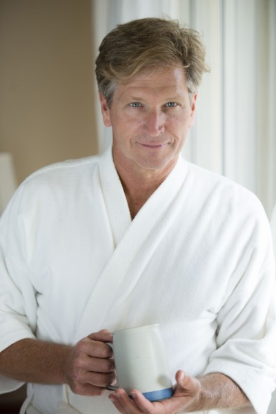 Caucasian man having coffee in bathrobe
