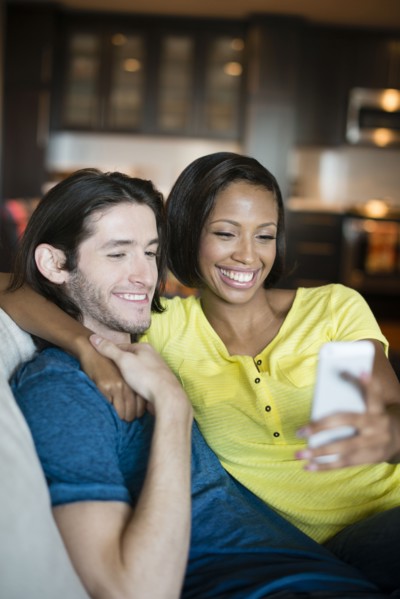 Couple taking self-portrait on sofa