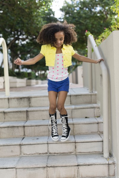 Mixed race girl jumping on steps
