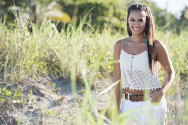 Mixed race woman smiling in tall grass
