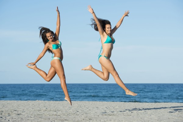 Women jumping for joy on beach