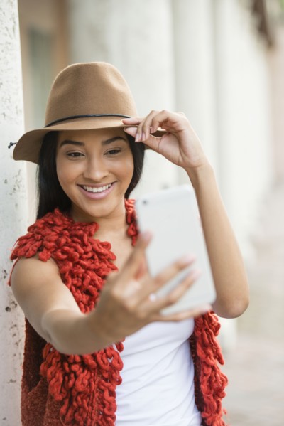Black woman taking cell phone selfie outdoors