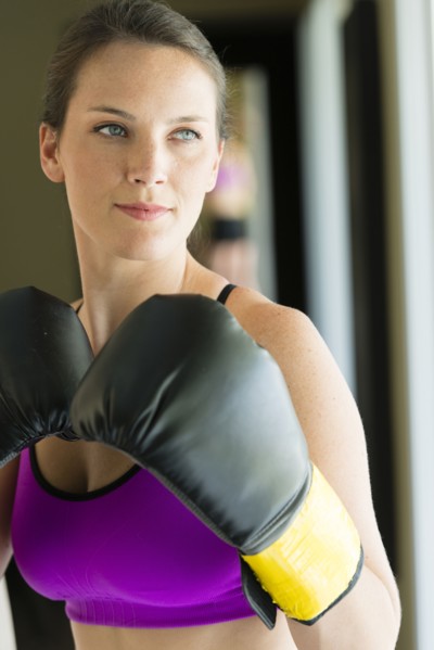 Caucasian woman with boxing gloves raised