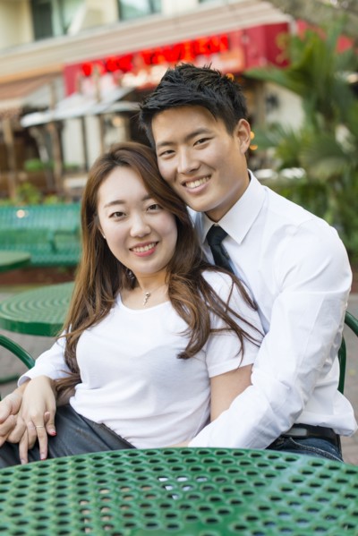 Korean couple hugging at sidewalk cafe